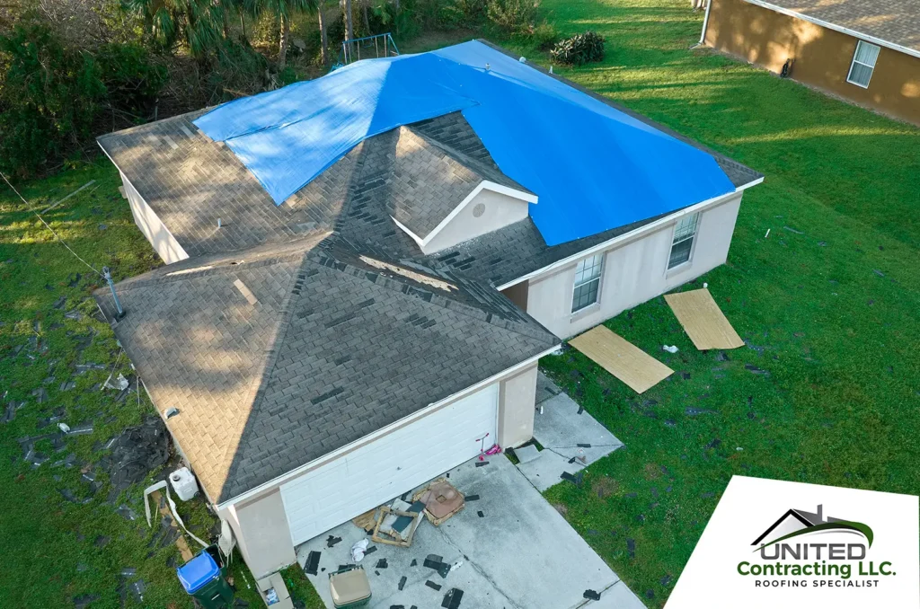 Top view of leaking house roof covered with protective tarp sheets against rain water